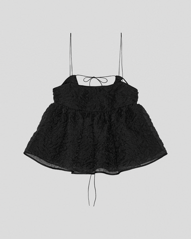 Sort peplum top med tynde stropper og struktureret stof. Flagrende bund tilføjer elegance.