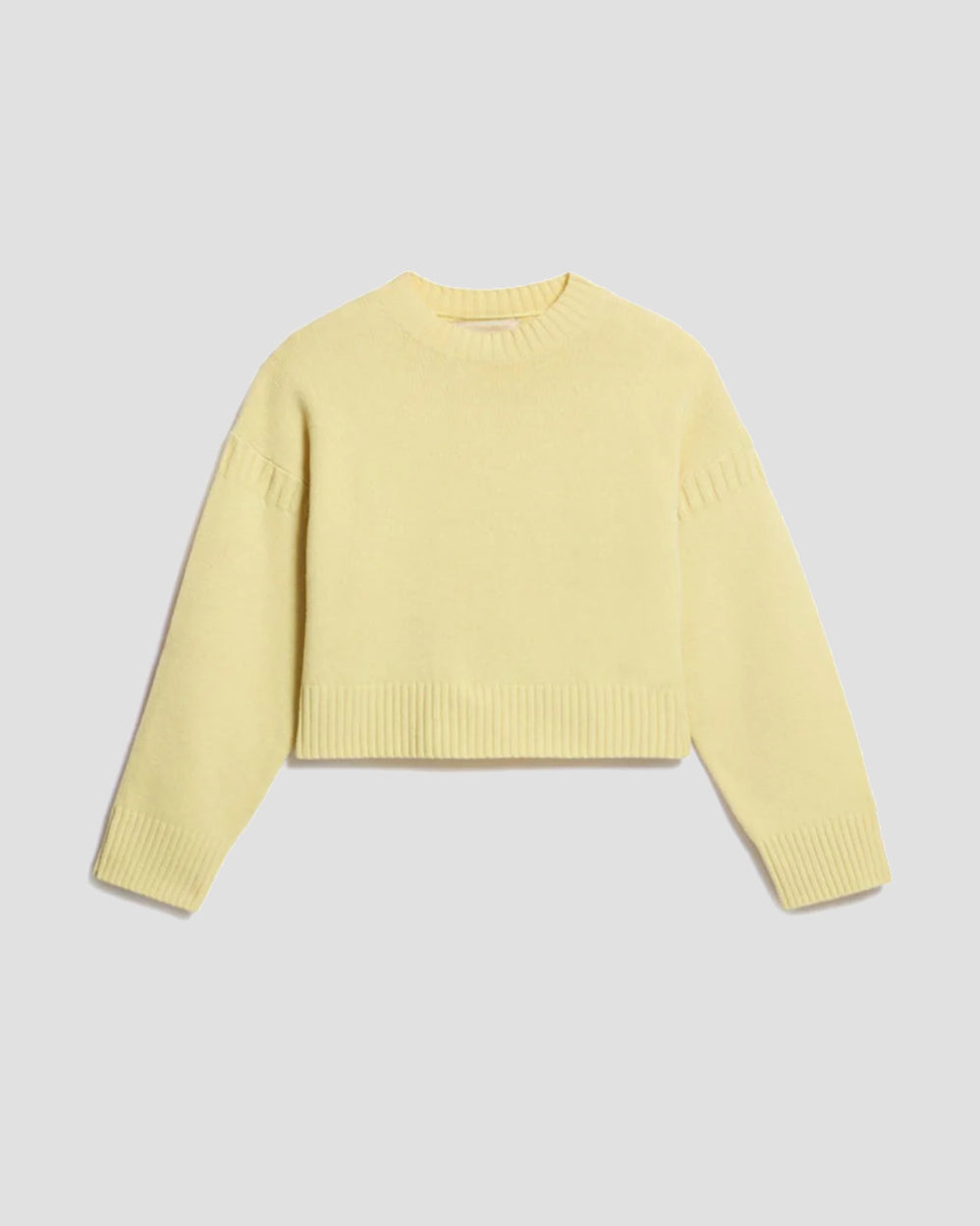 Pastelgul sweater med afslappet pasform, raglanærmer og ribdetaljer ved manchetter, kant og hals.