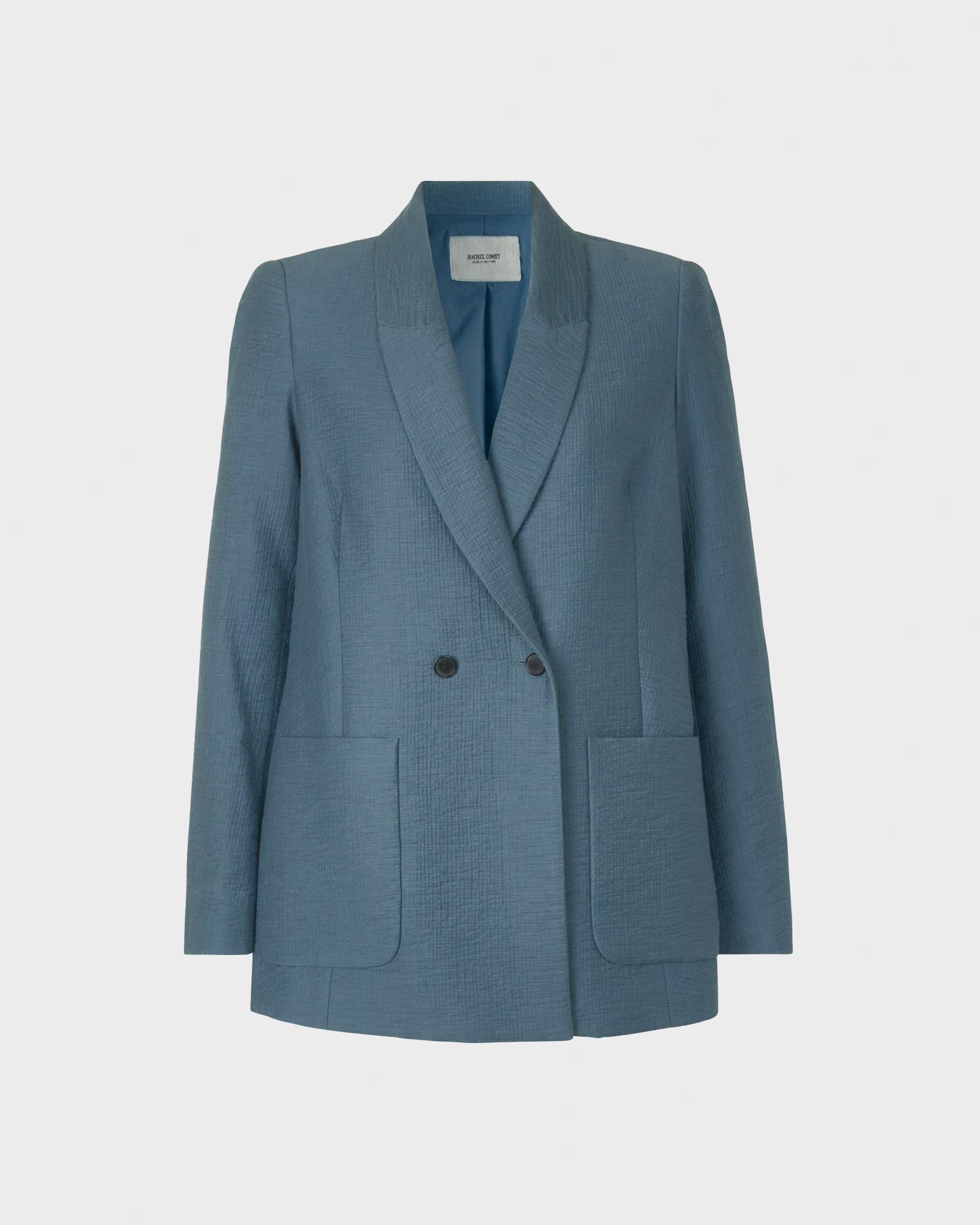 Blå blazer med tekstur, klassisk revers, dobbeltradet lukning og to frontlommer.