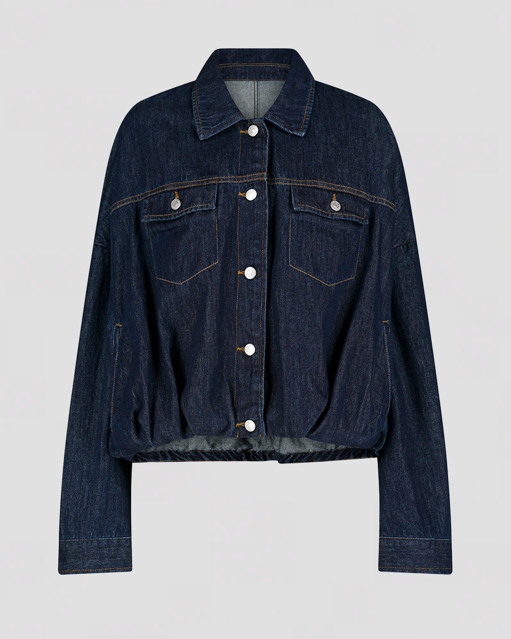 Mørk indigo denimjakke med sølvknapper, to brystlommer og krave. Oversized pasform med lange ærmer.